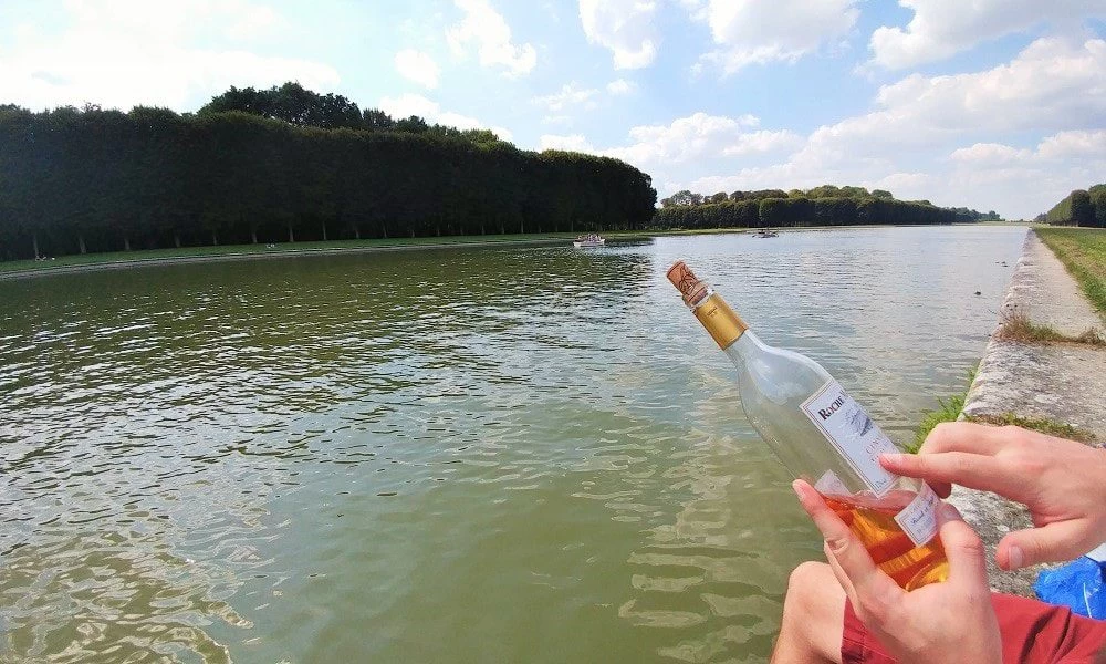 Yann and Shylo with wine by the river at The gardens of Versailles