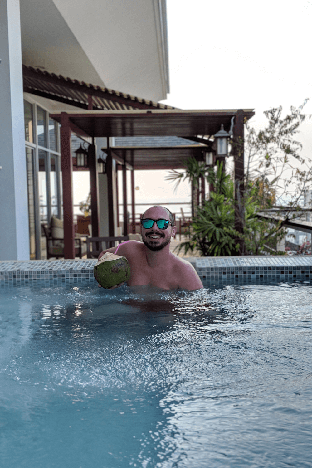 Yann holding a coconut in the private pool in Phuket